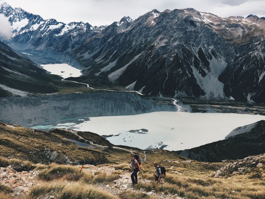Hikers exploring a rugged mountain landscape with stunning views of alpine lakes. Perfect for adventure and nature enthusiasts.