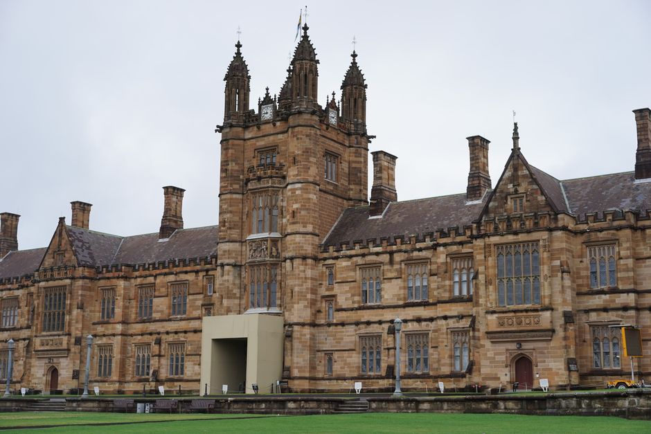 Gothic architecture of a historic university quadrangle building captured on a cloudy day.