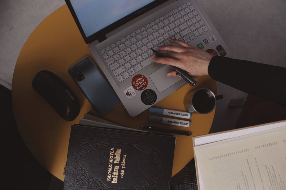 Overhead shot of a workspace in Turkey with a laptop, notebook, and coffee.